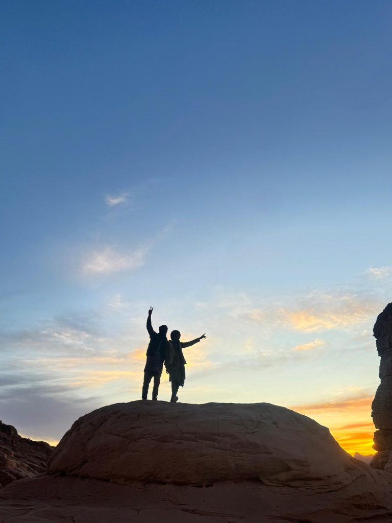 Deux voyageurs face au coucher de soleil
